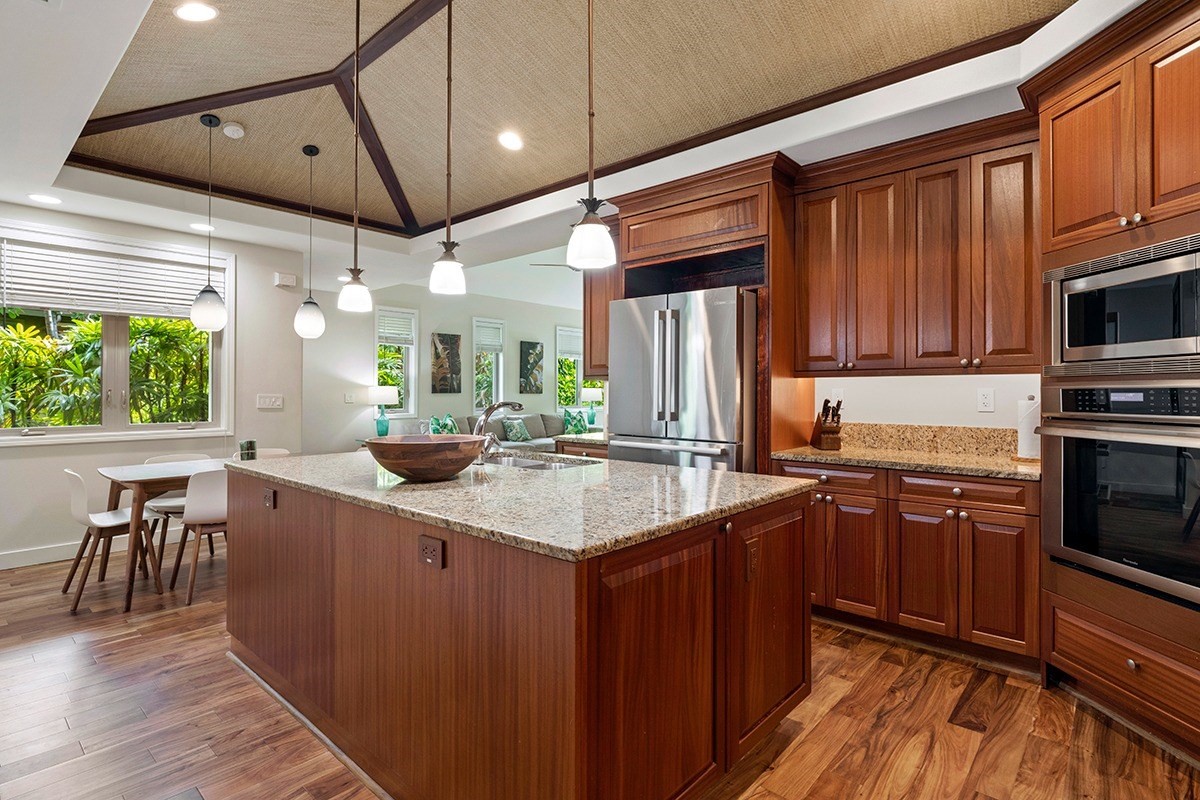 a kitchen with kitchen island granite countertop a sink appliances and cabinets