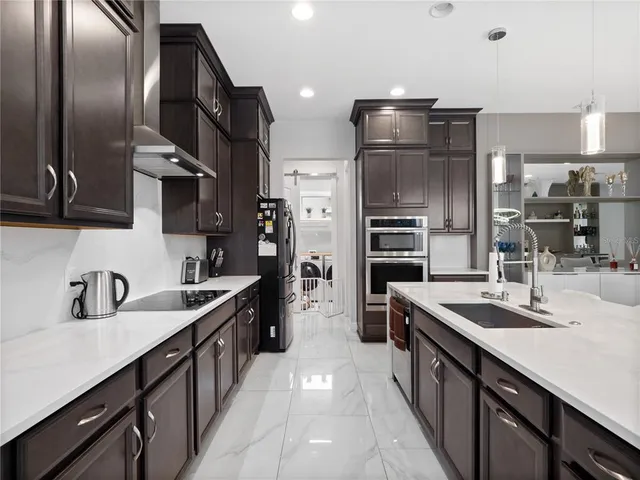 a kitchen with stainless steel appliances a sink stove and refrigerator