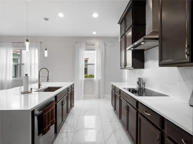 a kitchen with stainless steel appliances granite countertop a sink stove and cabinets