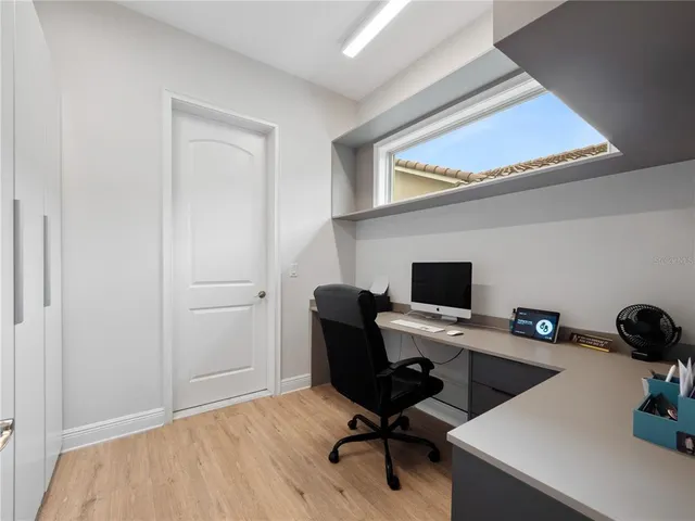 a view of a workspace with furniture and a window