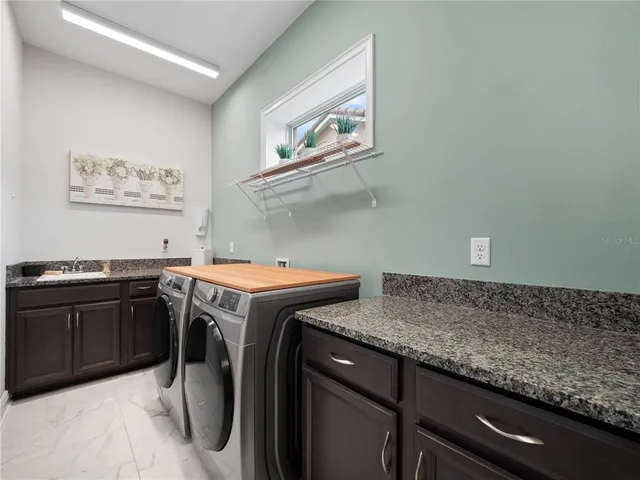 a utility room with sink dryer and washer