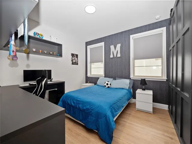 a bedroom with a bed and wooden floor