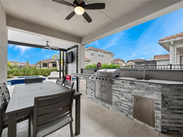 a kitchen with stainless steel appliances kitchen island granite countertop a table chairs and a refrigerator