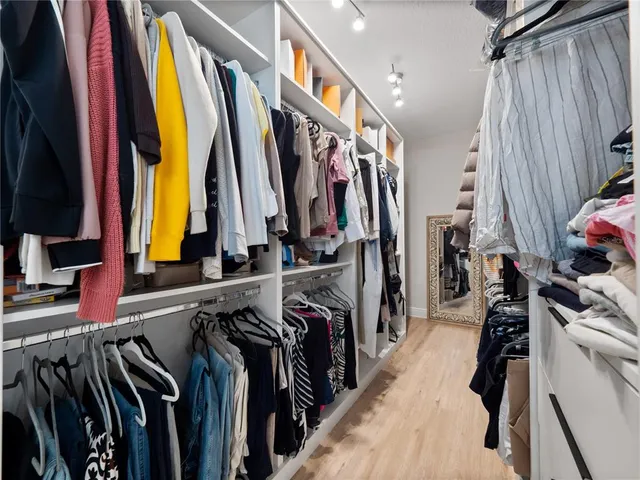a view of walk in closet with clothes and shoes