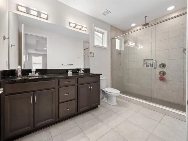 a bathroom with a granite countertop sink toilet and shower