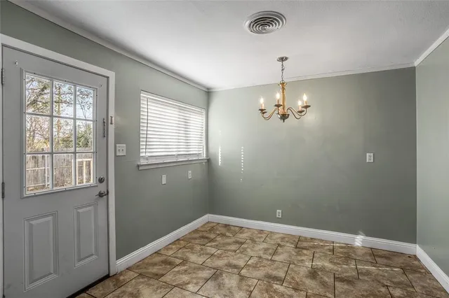 a view of a chandelier fan and window in an empty room