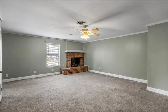 an empty room with windows and fireplace