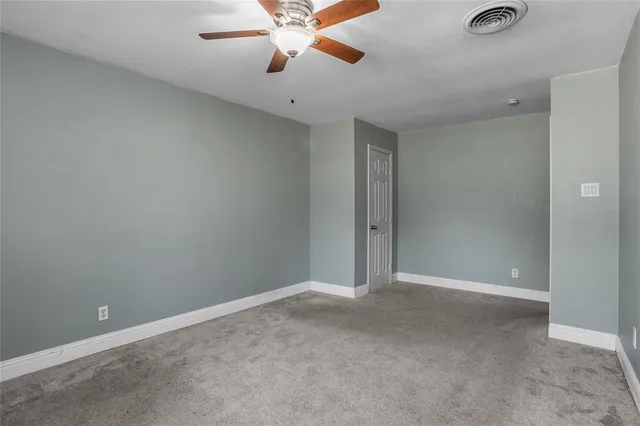 an empty room with a chandelier fan and a chandelier fan