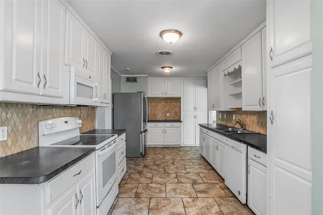 a kitchen with granite countertop a sink stove and cabinets