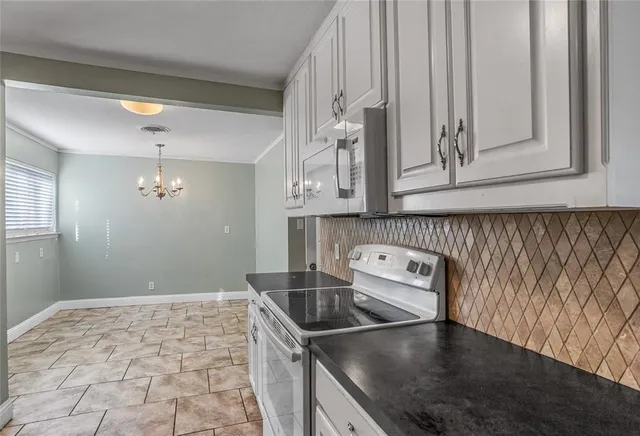 a kitchen with granite countertop a sink a stove and cabinets