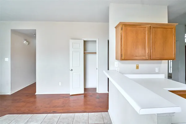 an empty room with wooden floor a ceiling fan and windows