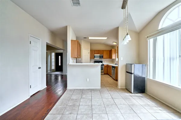 a view of a kitchen with a sink and dishwasher a refrigerator with wooden floor