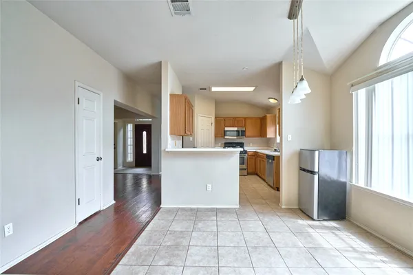 a large kitchen with kitchen island a sink a counter top space and stainless steel appliances