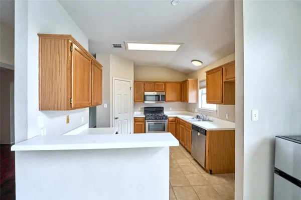 a kitchen with stainless steel appliances a sink stove and cabinets