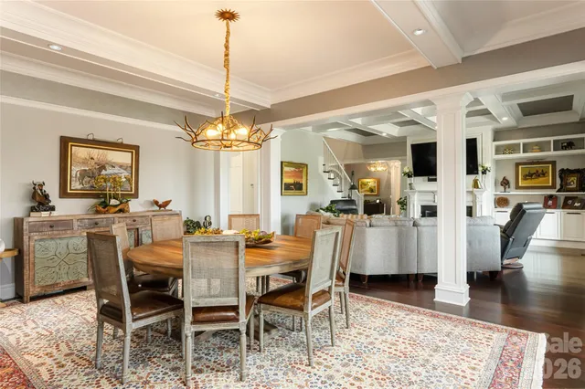 a dining room with furniture a chandelier and wooden floor