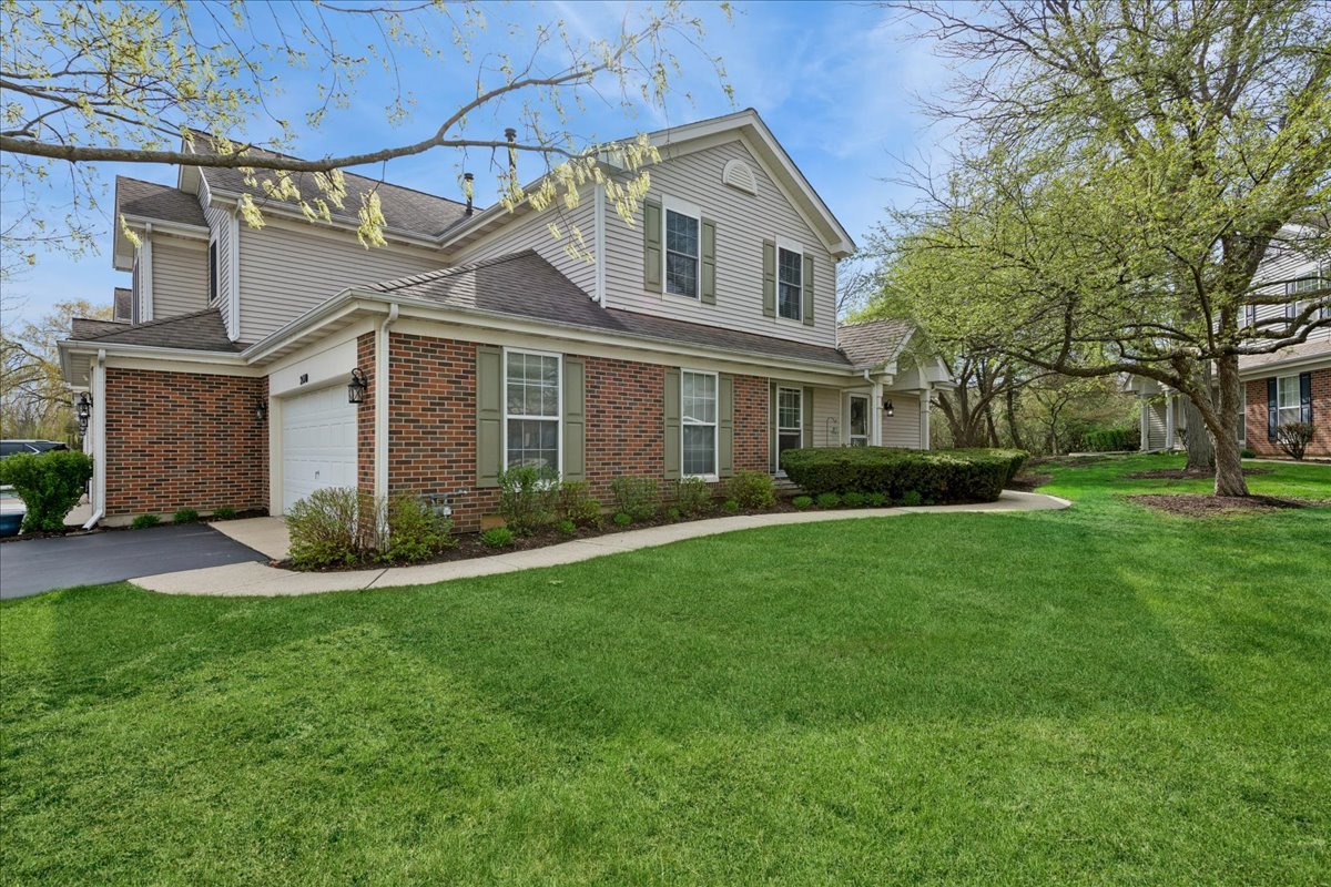 2110 Peach Tree Lane, Unit 2110 Algonquin, IL 60102 - Photo 19 of 21 a front view of a house with a garden and yard