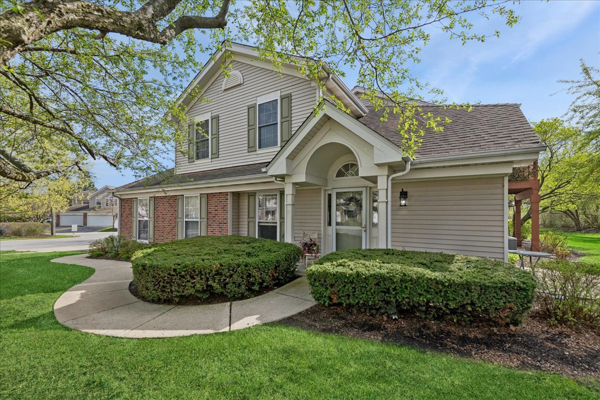 2110 Peach Tree Lane, Unit 2110 Algonquin, IL 60102 - Photo 2 of 21 a front view of a house with a garden