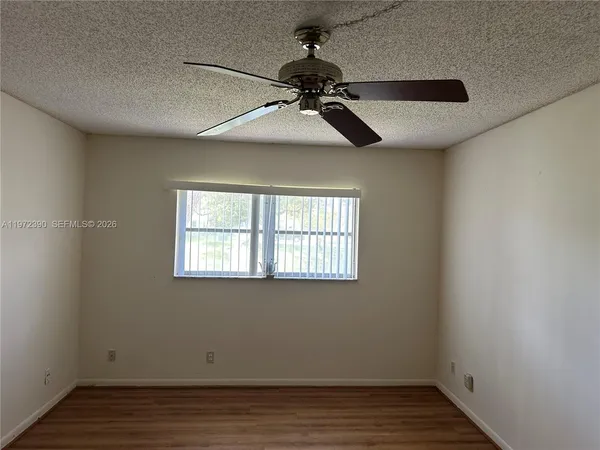 a view of a hallway with wooden floor and closet