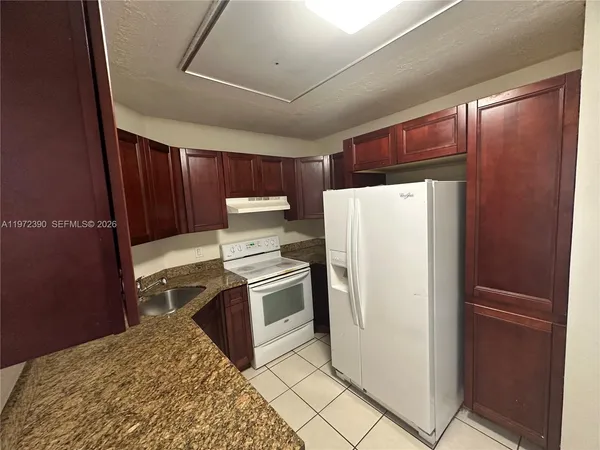 a kitchen with a refrigerator sink and cabinets