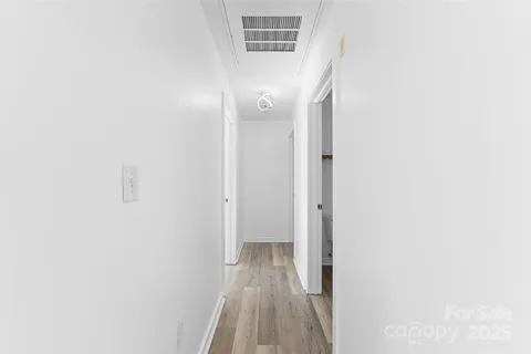 a view of a hallway with wooden floor