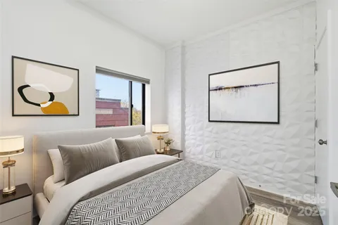 a bedroom with a bed and painting on the wall