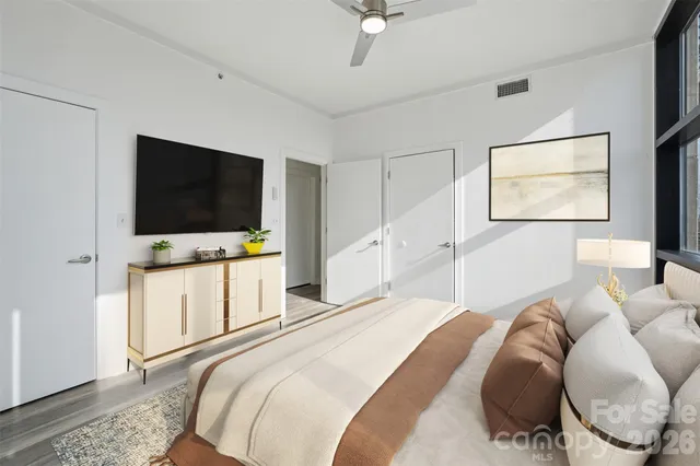 a bedroom with a bed tv and wooden floor