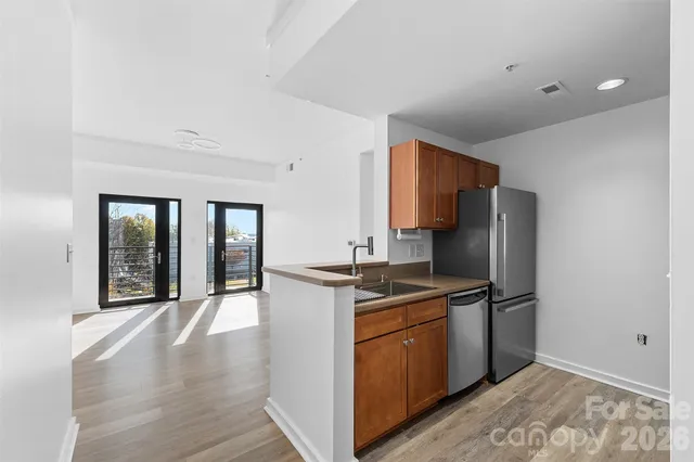 a kitchen with stainless steel appliances granite countertop a stove a refrigerator and a sink