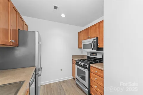 a kitchen with stainless steel appliances granite countertop a stove and a refrigerator