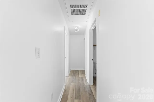 a view of a hallway with wooden floor