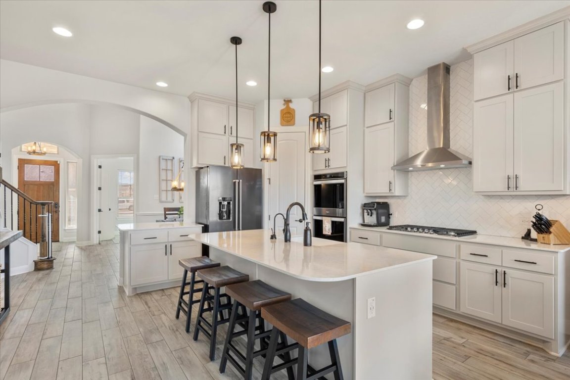 a kitchen with stainless steel appliances kitchen island a white table and chairs