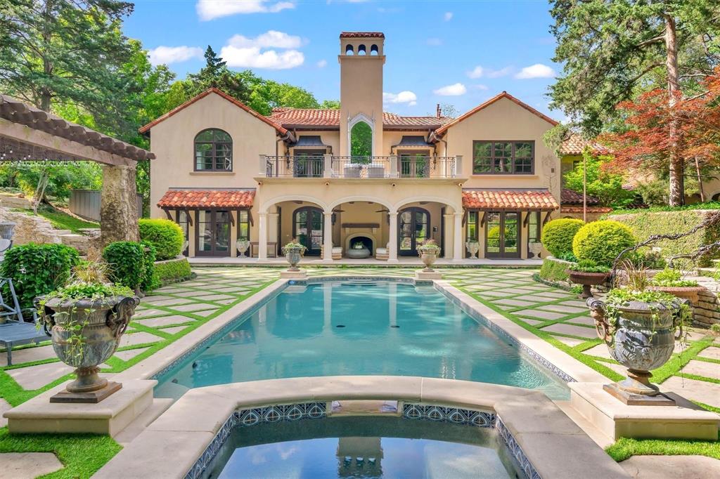 The property features a private swimming pool and spa, surrounded by a landscaped patio with stone pavers and green turf