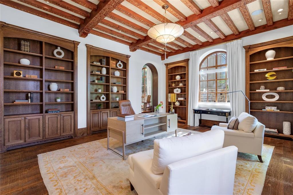 4612 Watauga Road Dallas, TX 75209 - Photo 17 of 32 A spacious study featuring a decorative wooden beamed ceiling, built-in wooden shelving, and hardwood floors