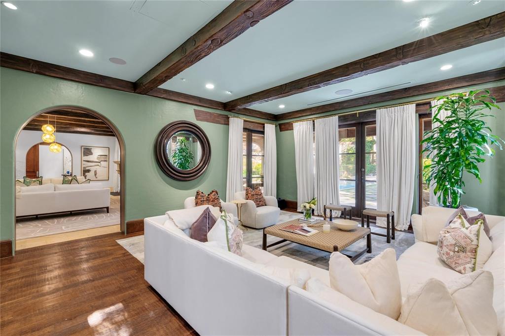 4612 Watauga Road Dallas, TX 75209 - Photo 18 of 32 Living room featuring hardwood floors, exposed wooden ceiling beams, and arched doorways