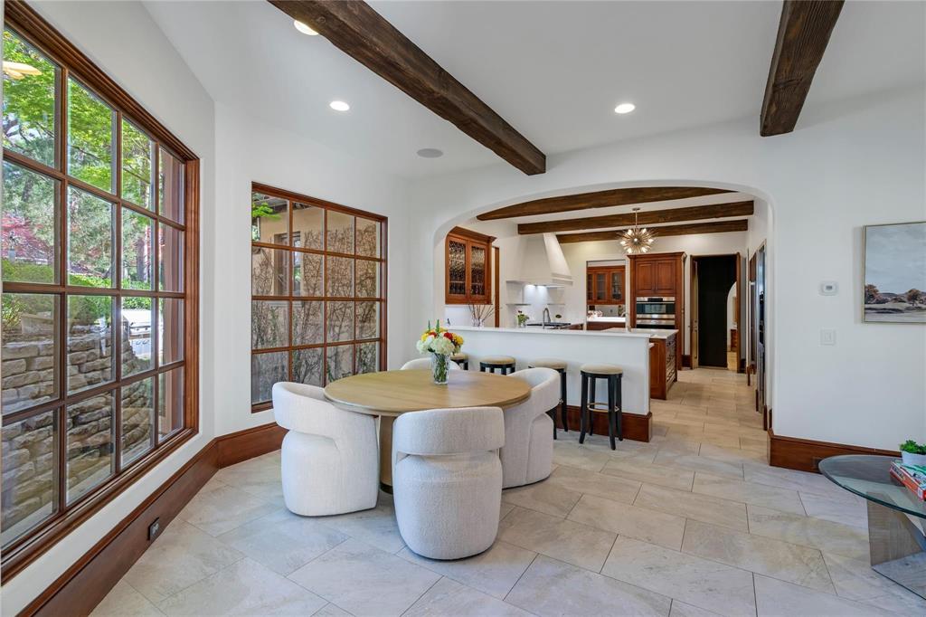 4612 Watauga Road Dallas, TX 75209 - Photo 20 of 32 This elegant dining area features exposed wood beams, large windows, and light-colored tile flooring