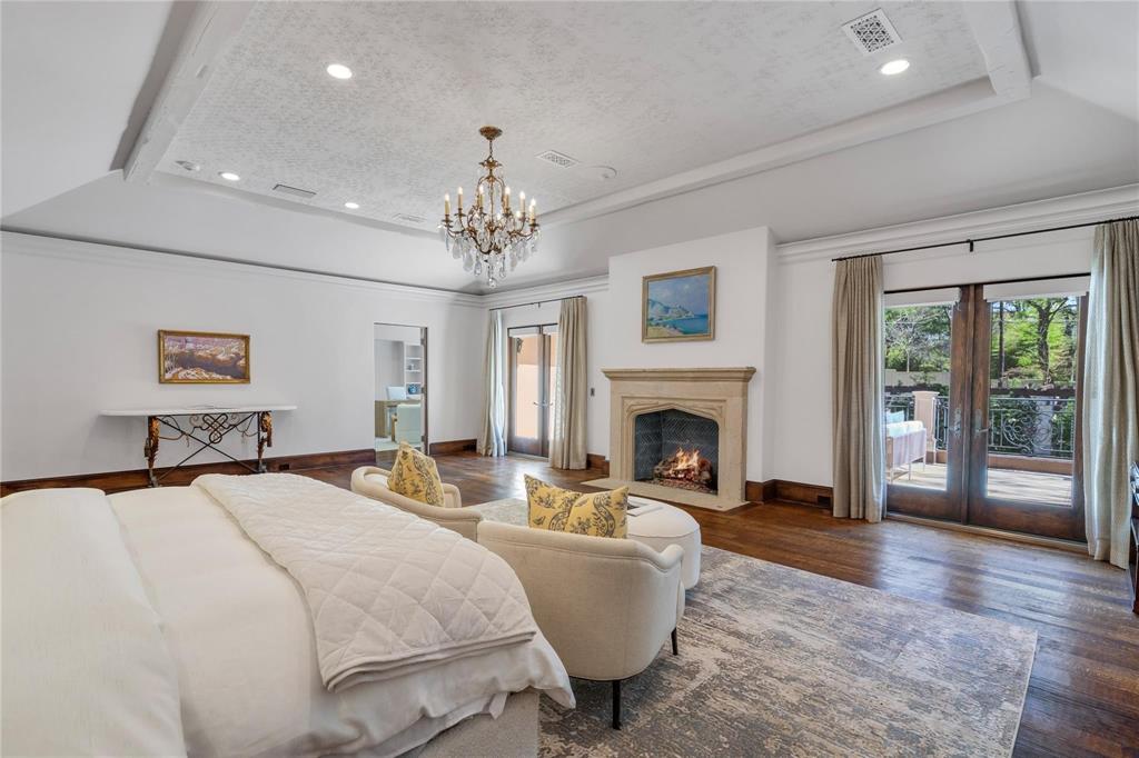 4612 Watauga Road Dallas, TX 75209 - Photo 21 of 32 This spacious room features rich hardwood flooring, a decorative tray ceiling with a chandelier, and a stone fireplace