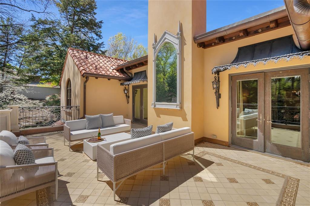4612 Watauga Road Dallas, TX 75209 - Photo 24 of 32 This property features an exterior patio with a tiled floor, decorative iron railings, and a tiled roof section