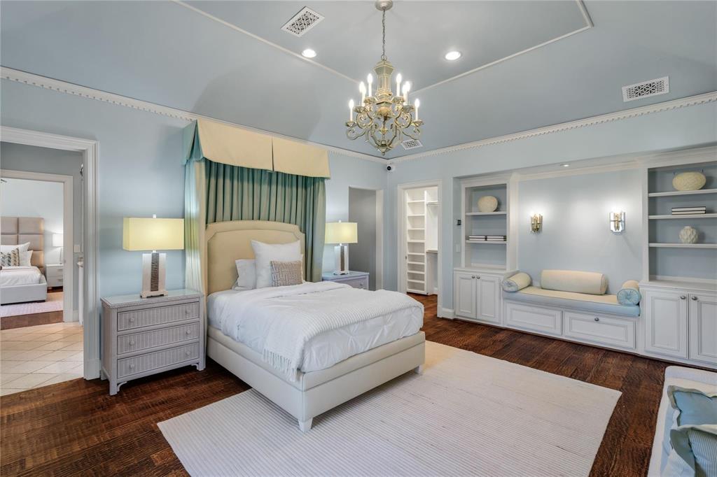 4612 Watauga Road Dallas, TX 75209 - Photo 27 of 32 This bedroom features rich hardwood flooring, a decorative chandelier, and built-in shelving with integrated lighting