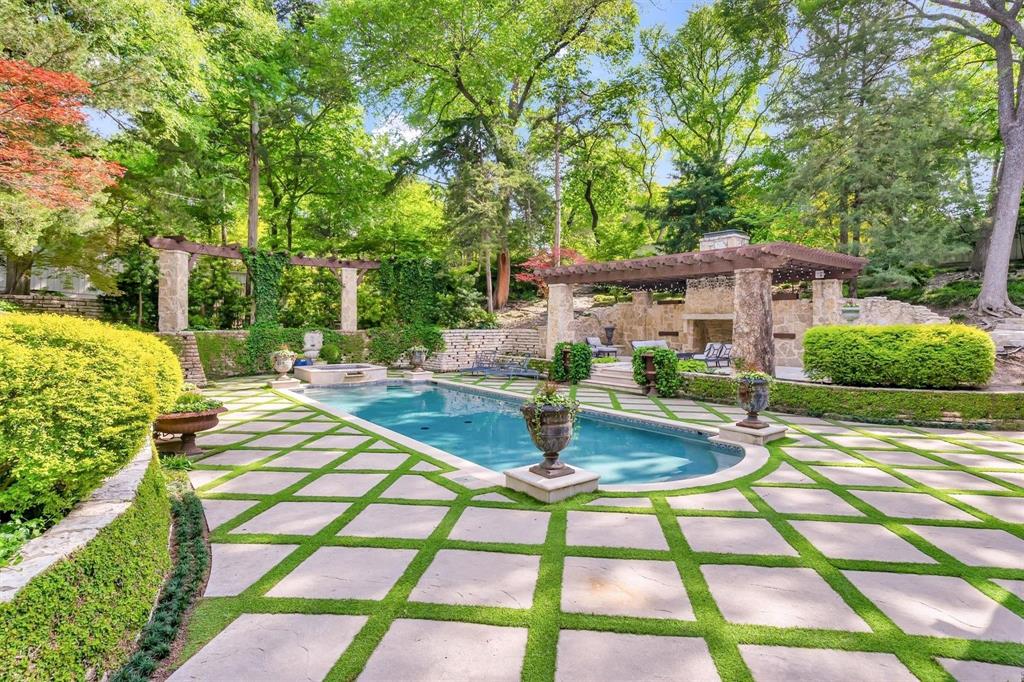 4612 Watauga Road Dallas, TX 75209 - Photo 3 of 32 The property features an outdoor swimming pool, a patio area with a pergola, and a stone outdoor fireplace