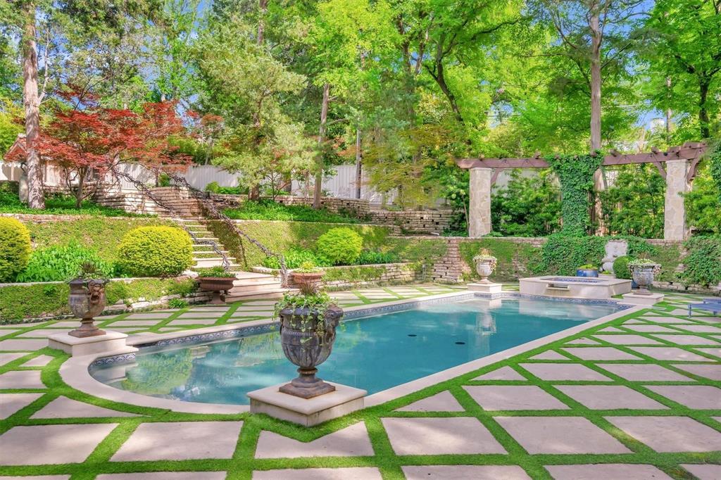 4612 Watauga Road Dallas, TX 75209 - Photo 6 of 32 The property features an outdoor swimming pool, a spa, and a stone patio with a distinct geometric pattern and lush green accents
