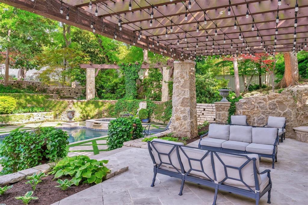 4612 Watauga Road Dallas, TX 75209 - Photo 7 of 32 The property features a patio with stone flooring and a wooden pergola adorned with string lights