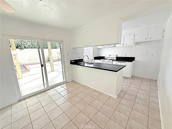 a kitchen with stainless steel appliances a sink stove and white cabinets