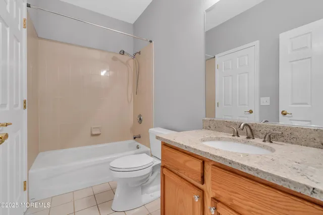 a bathroom with a granite countertop sink a toilet and shower