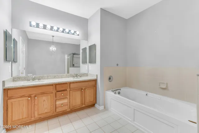 a spacious bathroom with a bathtub a mirror a double vanity sink and vanity