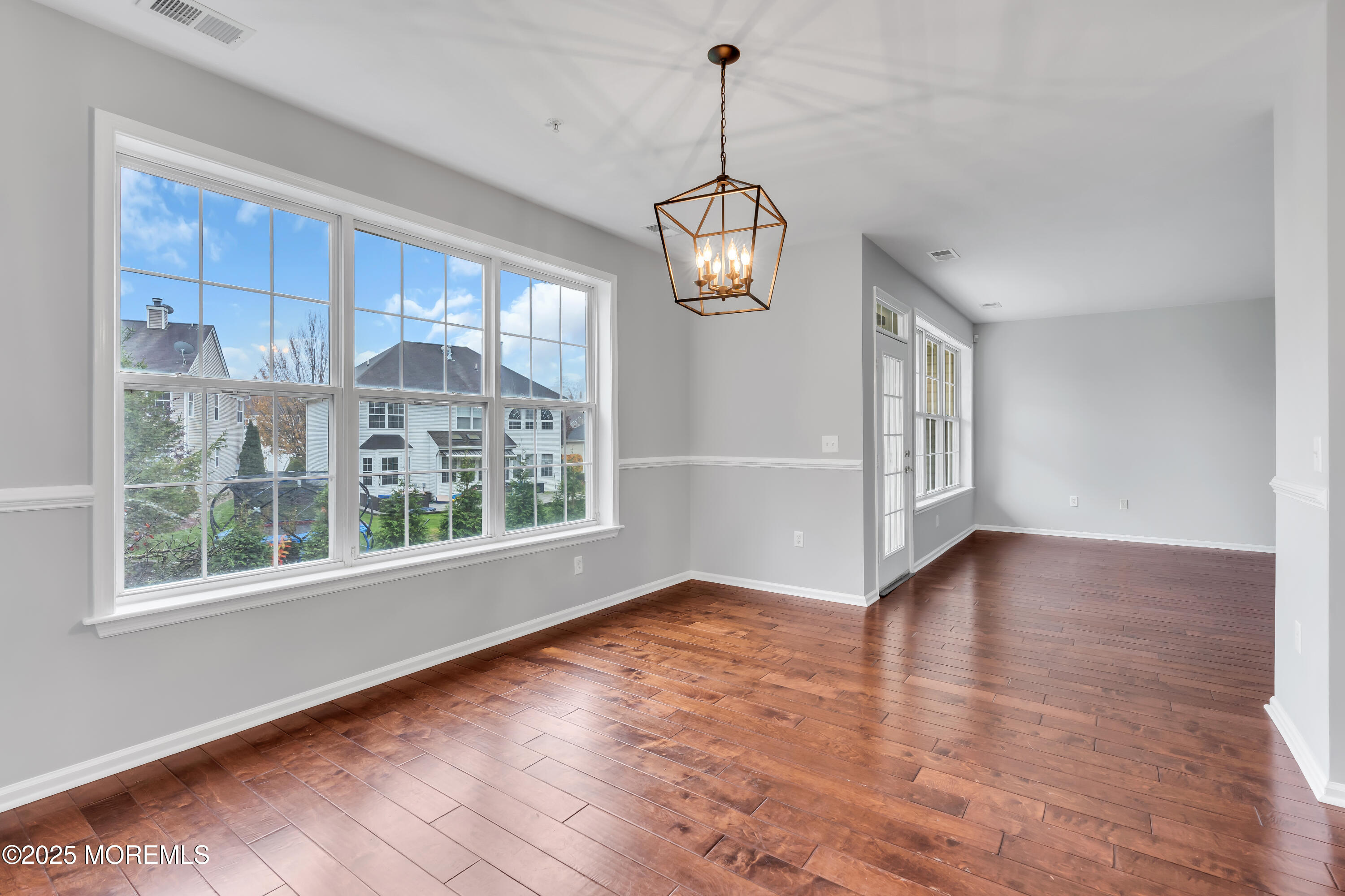 694 St Andrews Place Manalapan, NJ 07726 - Photo 18 of 26 a view of an empty room with wooden floor and a window