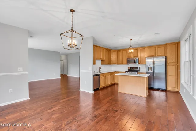 a large kitchen with white cabinets stainless steel appliances and center island