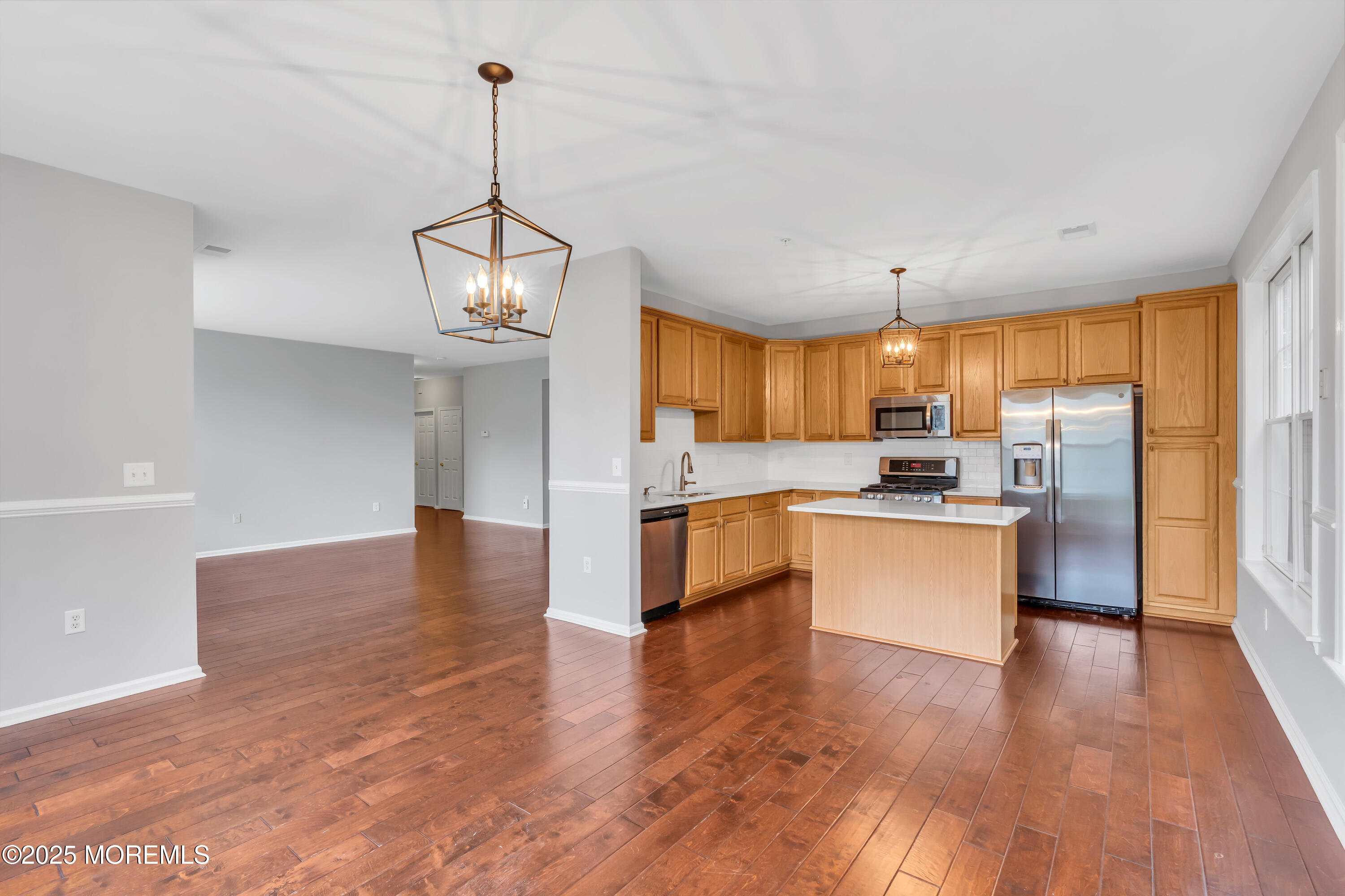 694 St Andrews Place Manalapan, NJ 07726 - Photo 19 of 26 a large kitchen with white cabinets stainless steel appliances and center island