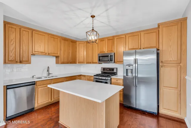 a kitchen with stainless steel appliances a refrigerator sink and microwave