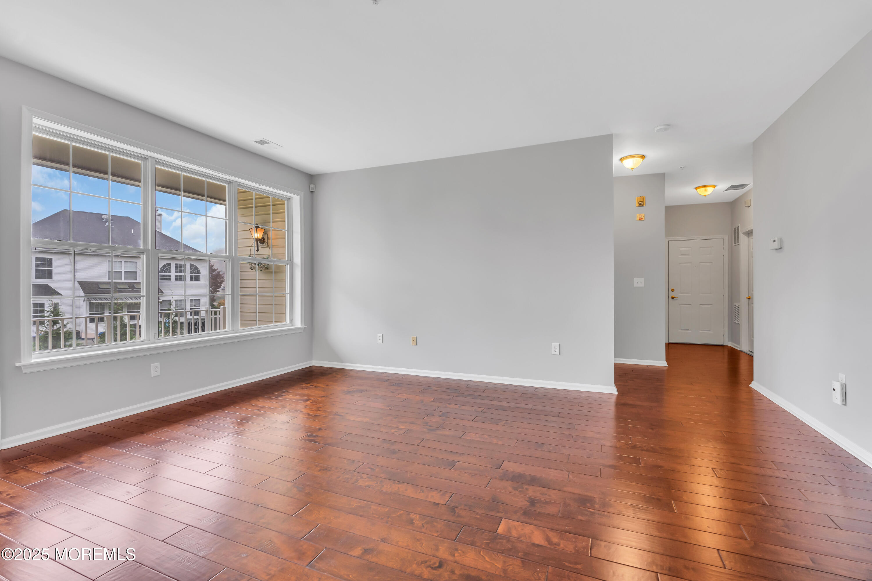 694 St Andrews Place Manalapan, NJ 07726 - Photo 4 of 26 a view of an empty room with wooden floor and a window