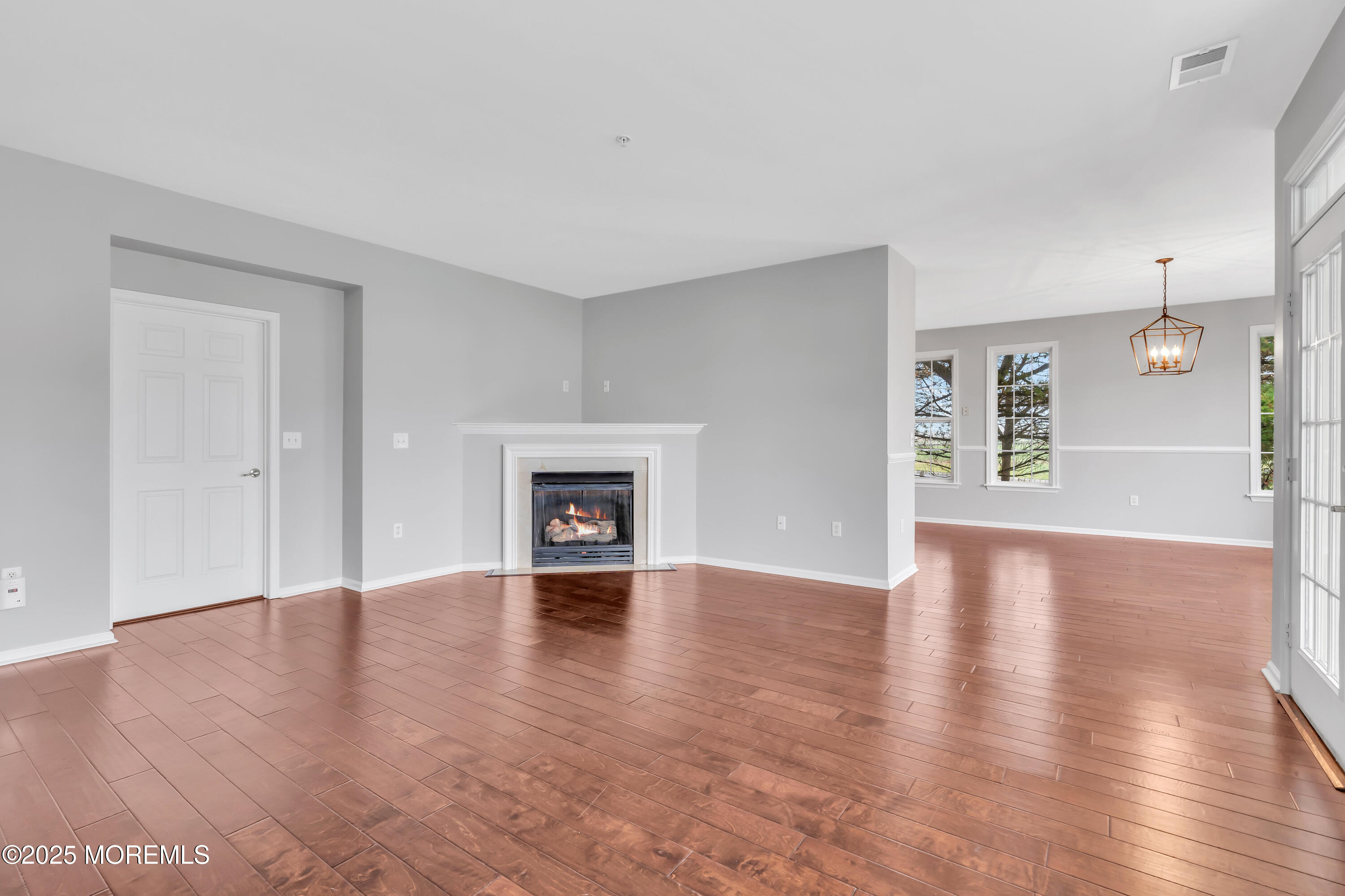 694 St Andrews Place Manalapan, NJ 07726 - Photo 8 of 26 a view of an empty room with window and wooden floor