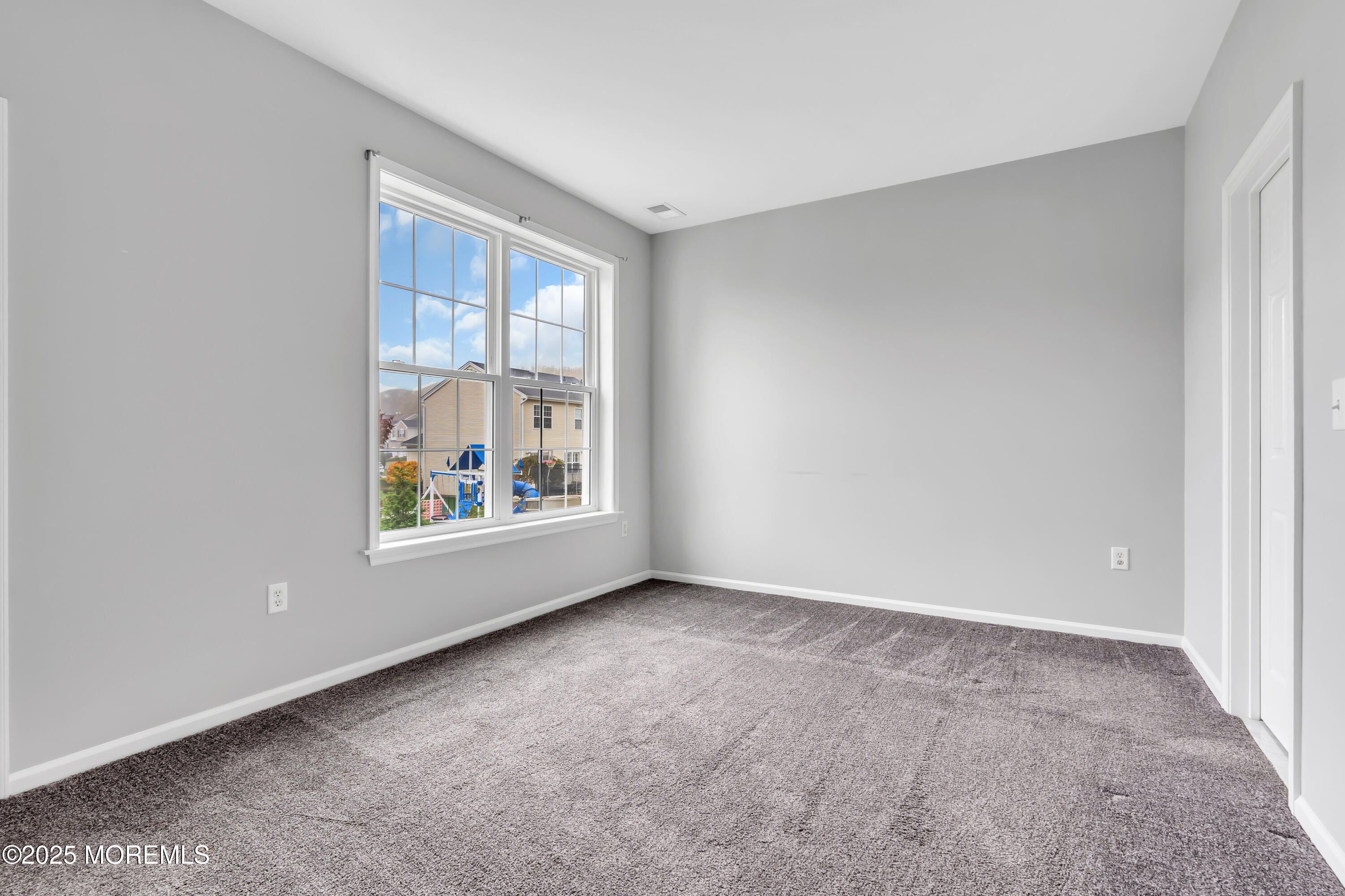 694 St Andrews Place Manalapan, NJ 07726 - Photo 9 of 26 an empty room with windows and back door